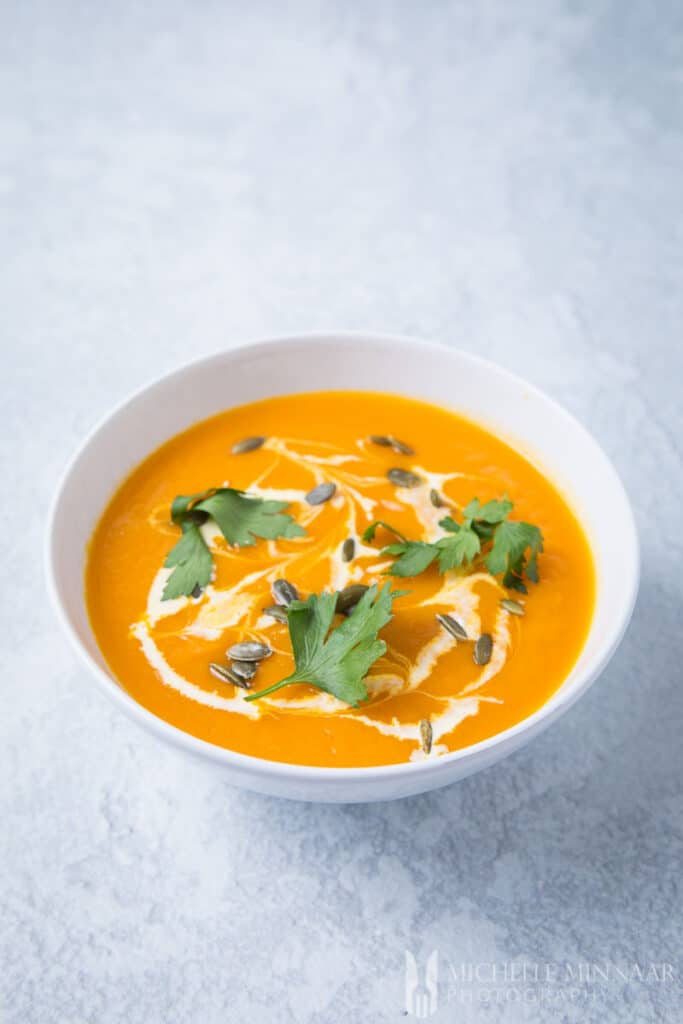 A bowl of orange pumpkin and sweet potato soup