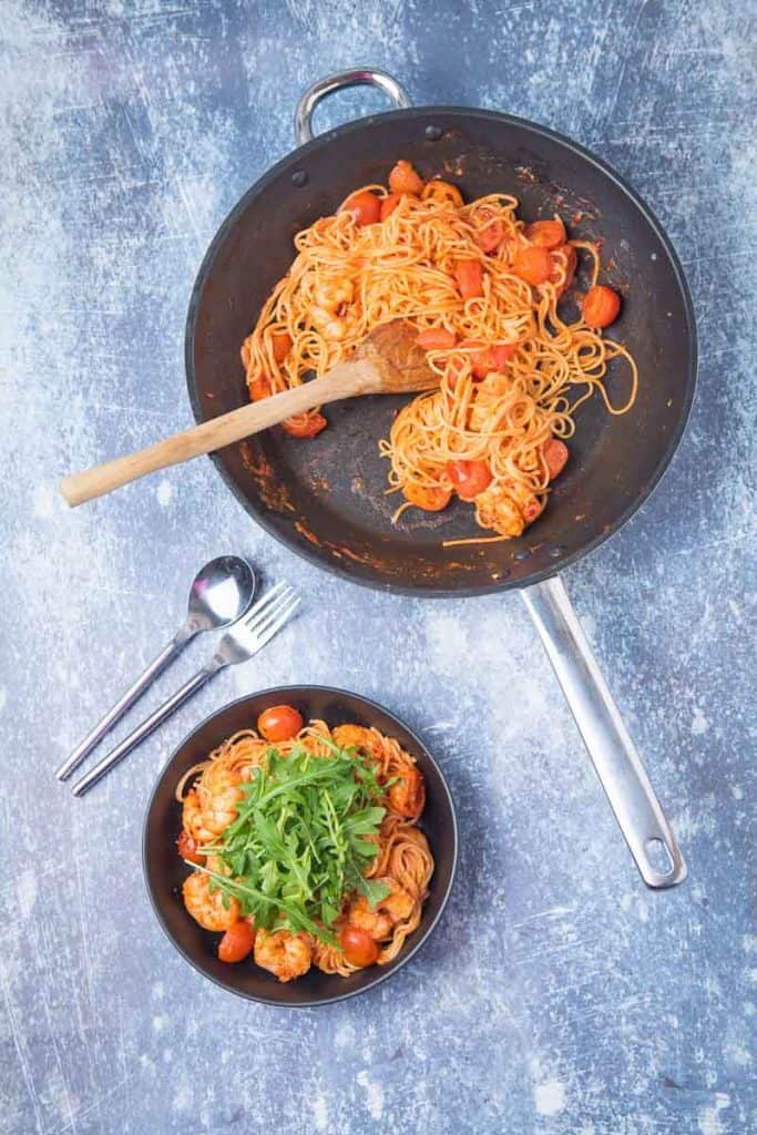 A saute pan of pasta and a bowl of chilli prawn pasta