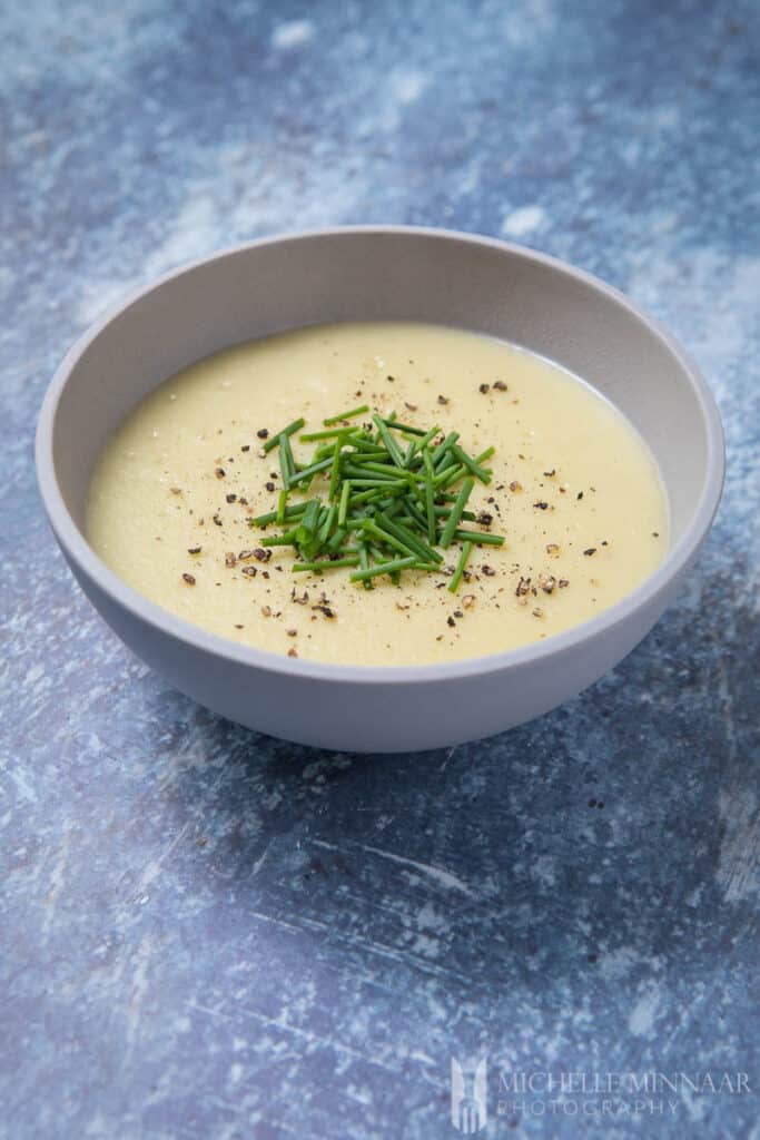 a bowl of leek and potato soup garnished with chives