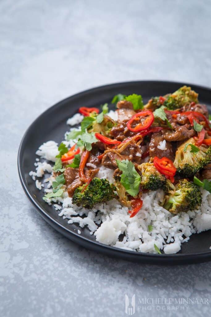 A plate of lamb stir fry over white rice 