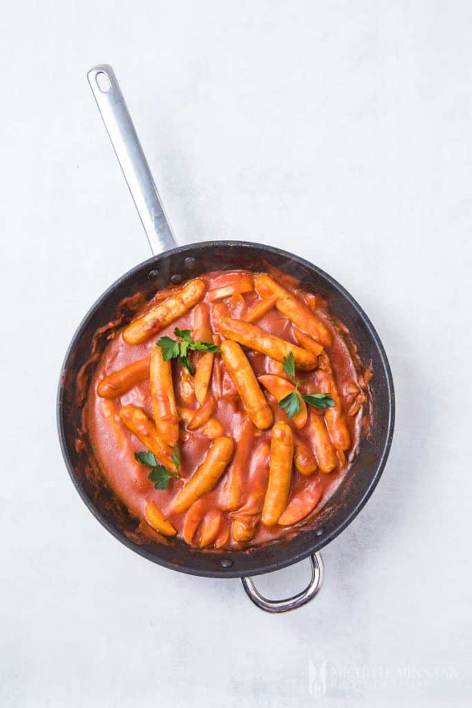 Sausages stewing in a orange sauce 