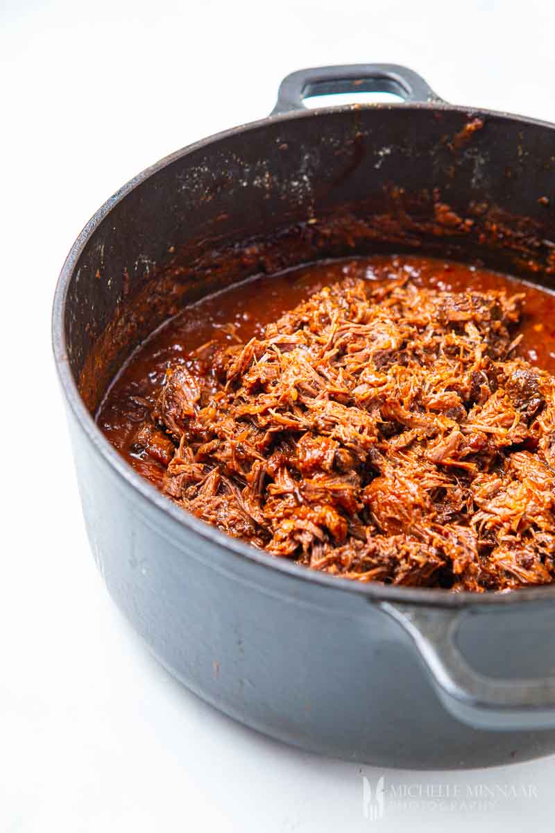 shredded beef in a pot simmering