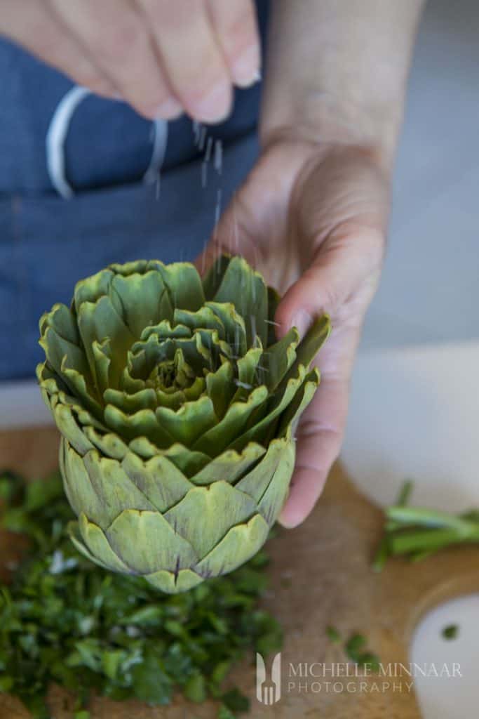 Salt Sprinkling on an artichoke