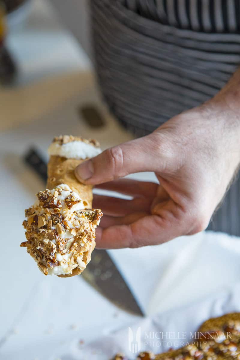A cannoli with almond brittle on the end