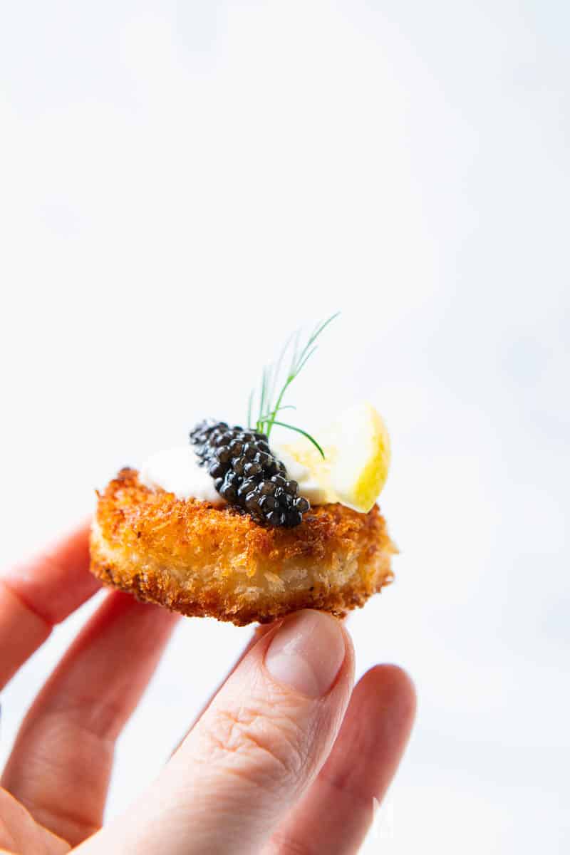 A close up of a fried canape with caviar on it 