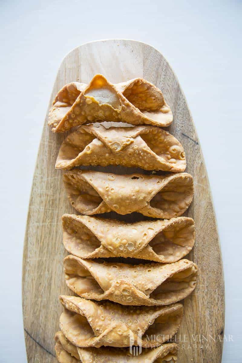 Empty brown cannoli Shells on a cutting board