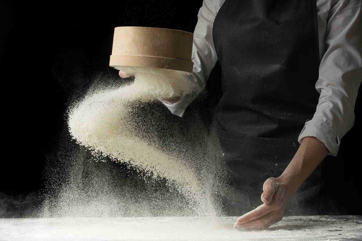 A man throwing masa harina flour