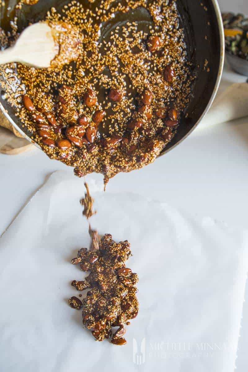 almond brittle being poured out onto a counter