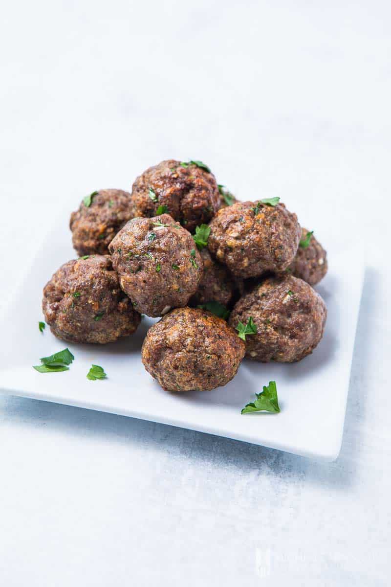 A plate full of browned air fryer meatballs
