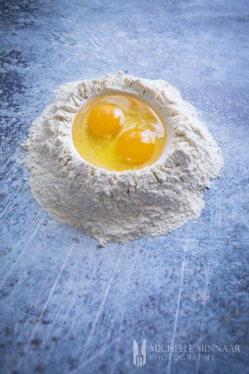 A pile of flour with an egg in the middle