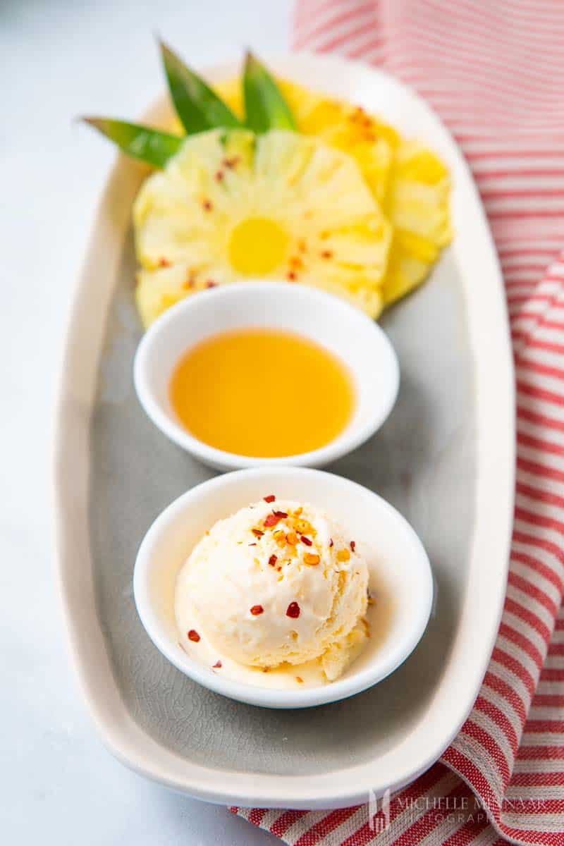 A scoop of pineapple ice cream and fresh pineapple