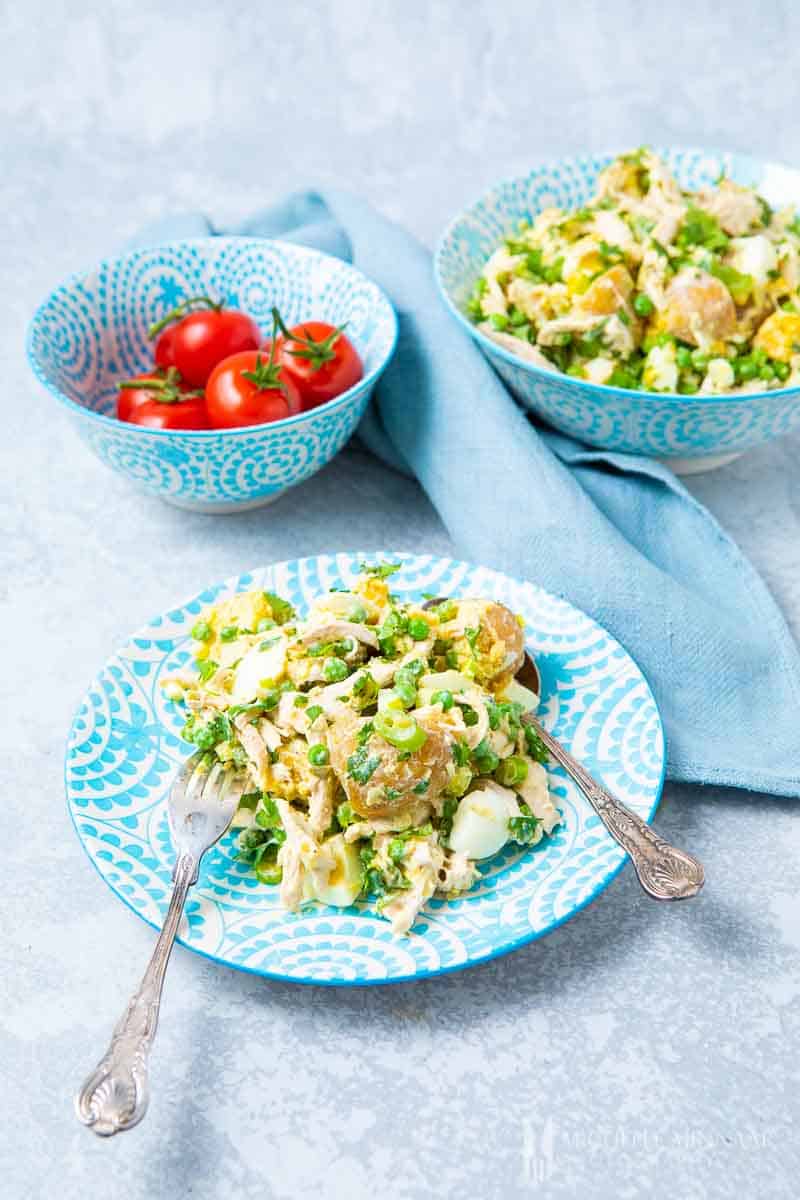 A plate of salad olivieh and a bowl of tomatoes