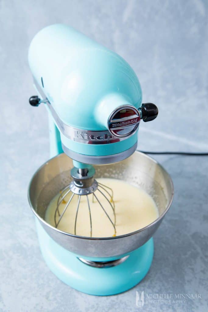 The blender mixing a bowl of liquid to make lemon chess pie