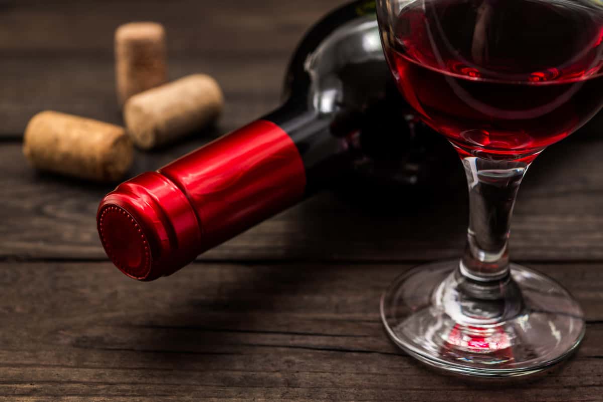 One red glass of wine and one wine bottle with a red label