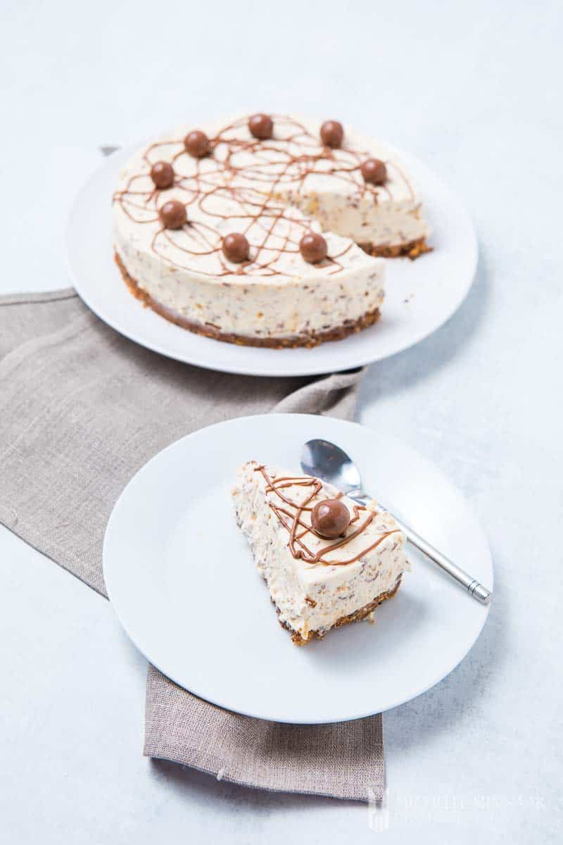A full cake with a slice on a plate