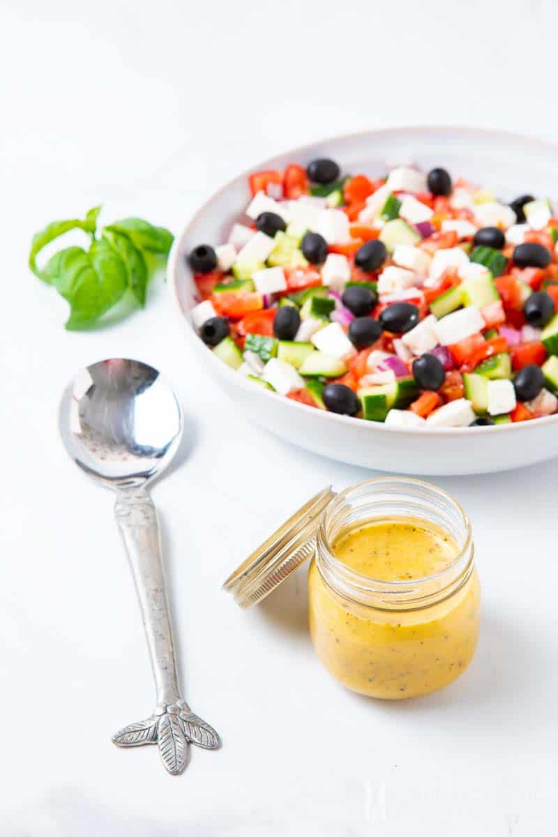 A greek salad with a jar of Mediterranean Salad Dressing