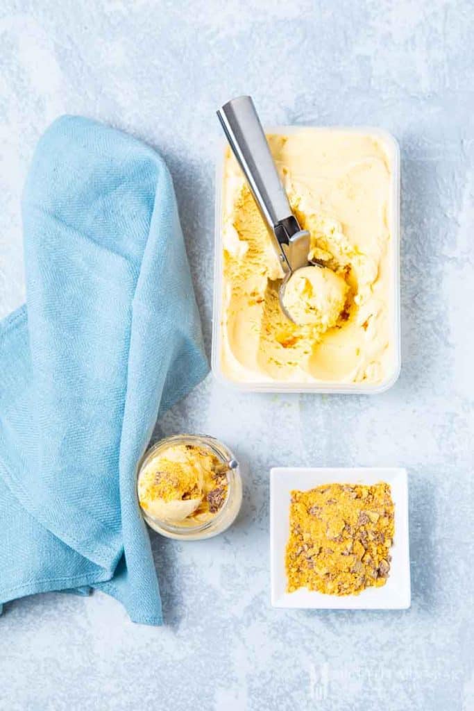 A scoop of hokey pokey ice cream with a bowl of it next to it