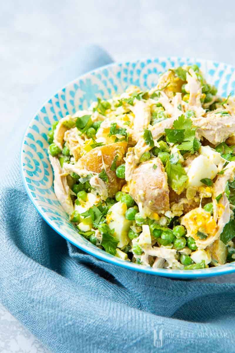 A close up of potatoes, chicken and peas