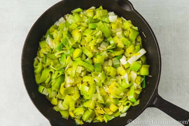 Simmering leeks in a pan.