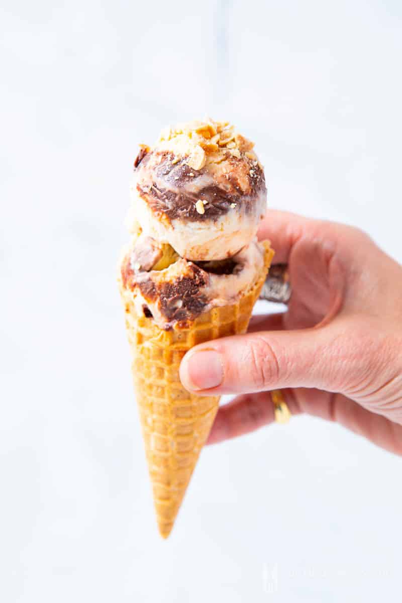 Close of of two scoops of tin roof ice cream on a sugar cone
