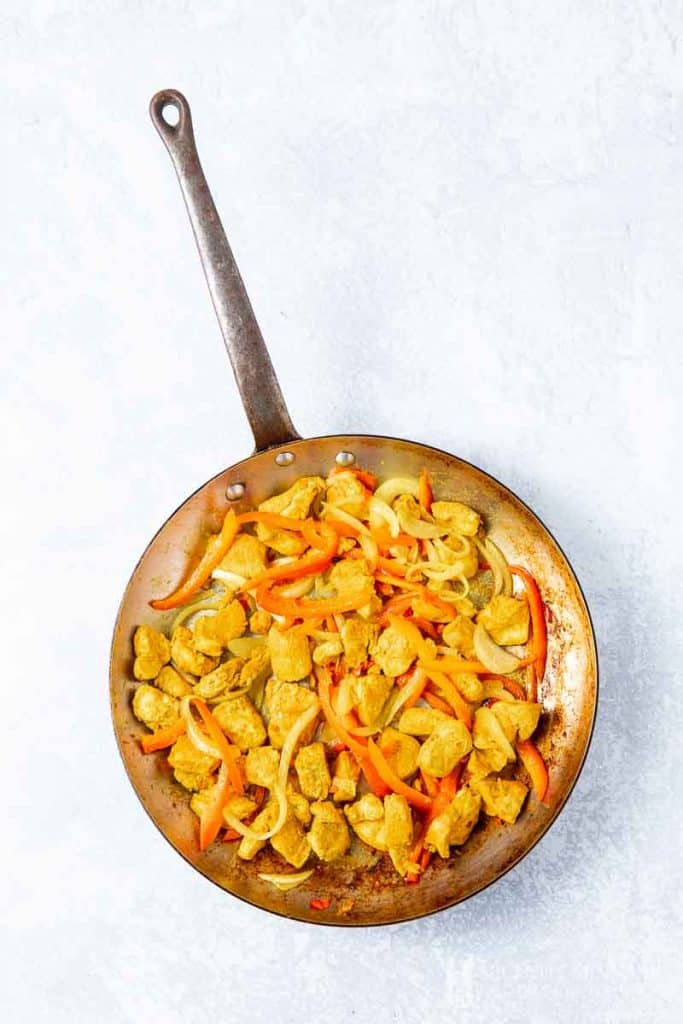 Chicken, gingers and peppers simmering in a pan 