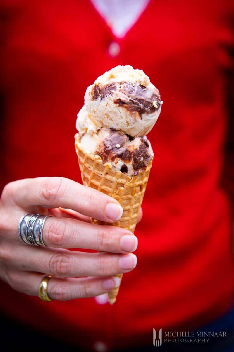 Two scoops of tin roof ice cream in a cone