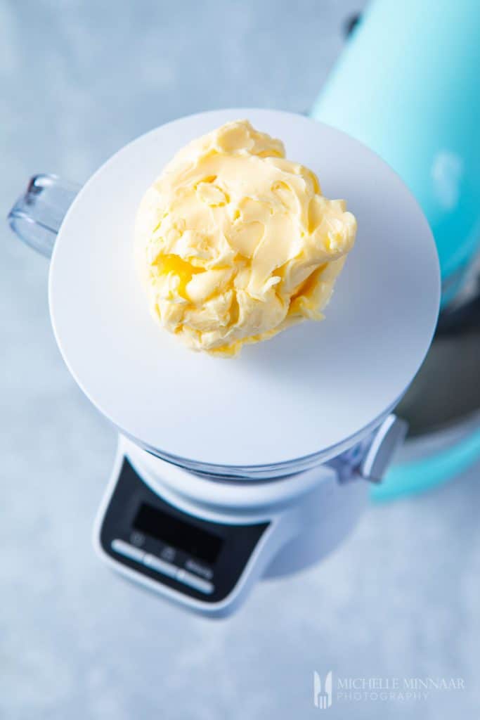 A scoop of butter on a measuring scale