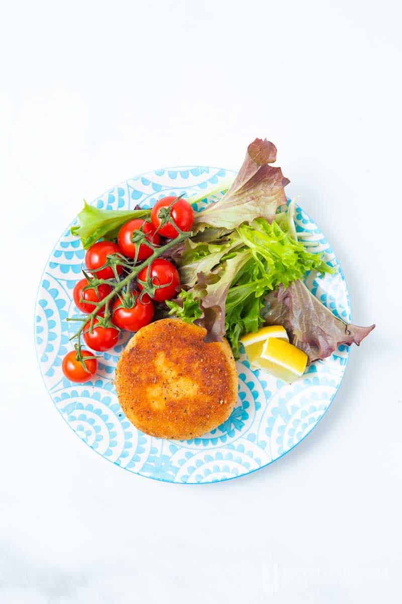 An aerial view of a salmon fish cake and salad 