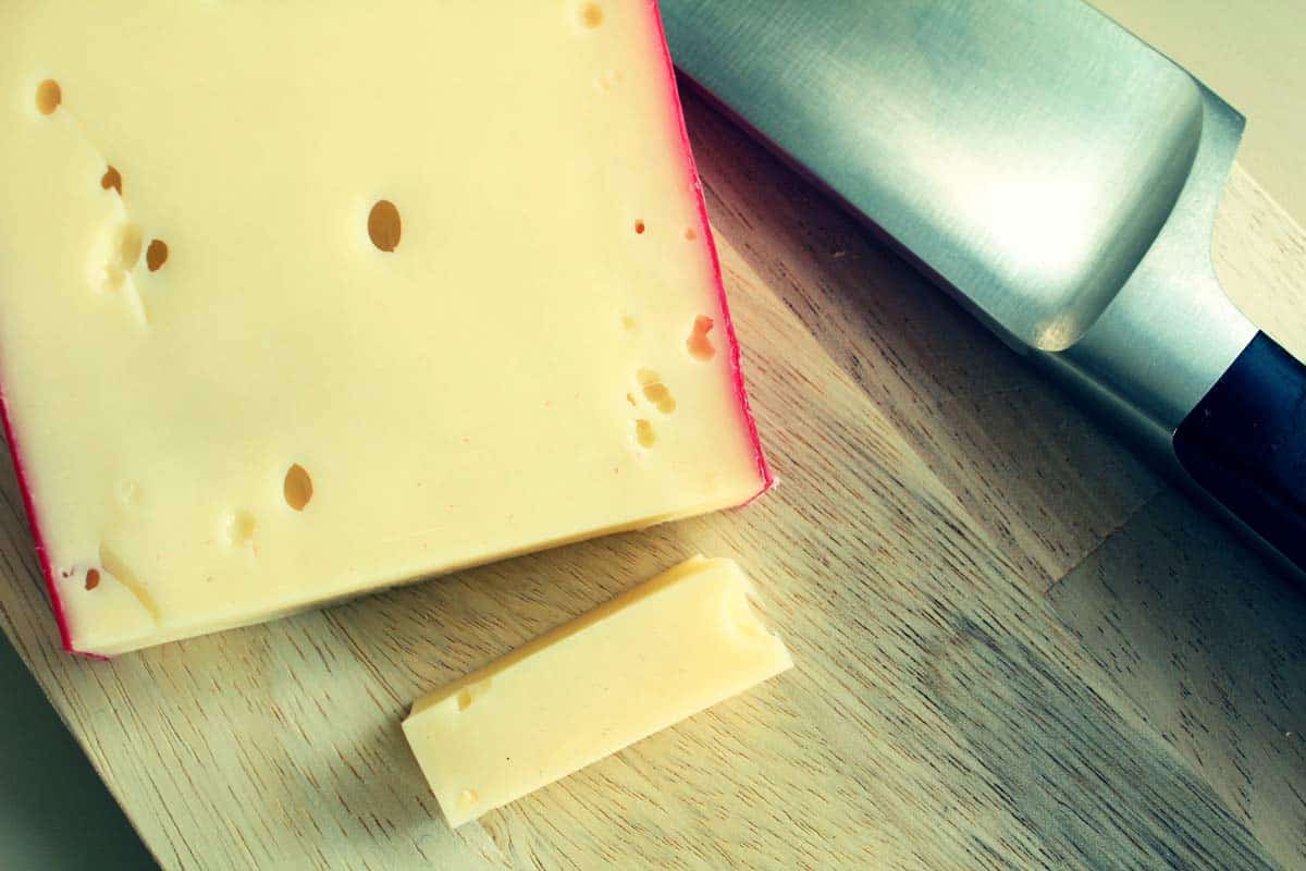 A white block of fontina cheese with a red crust