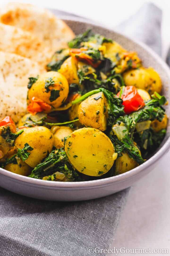 Saag Aloo served in a bowl with naan.