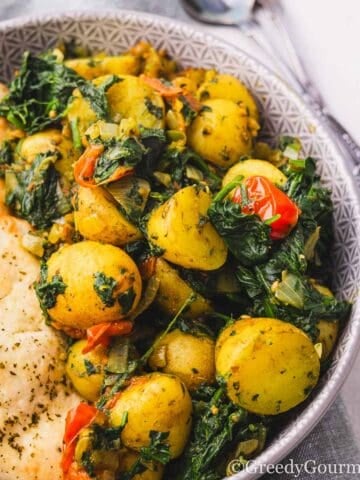 Saag Aloo served in a bowl with naan.