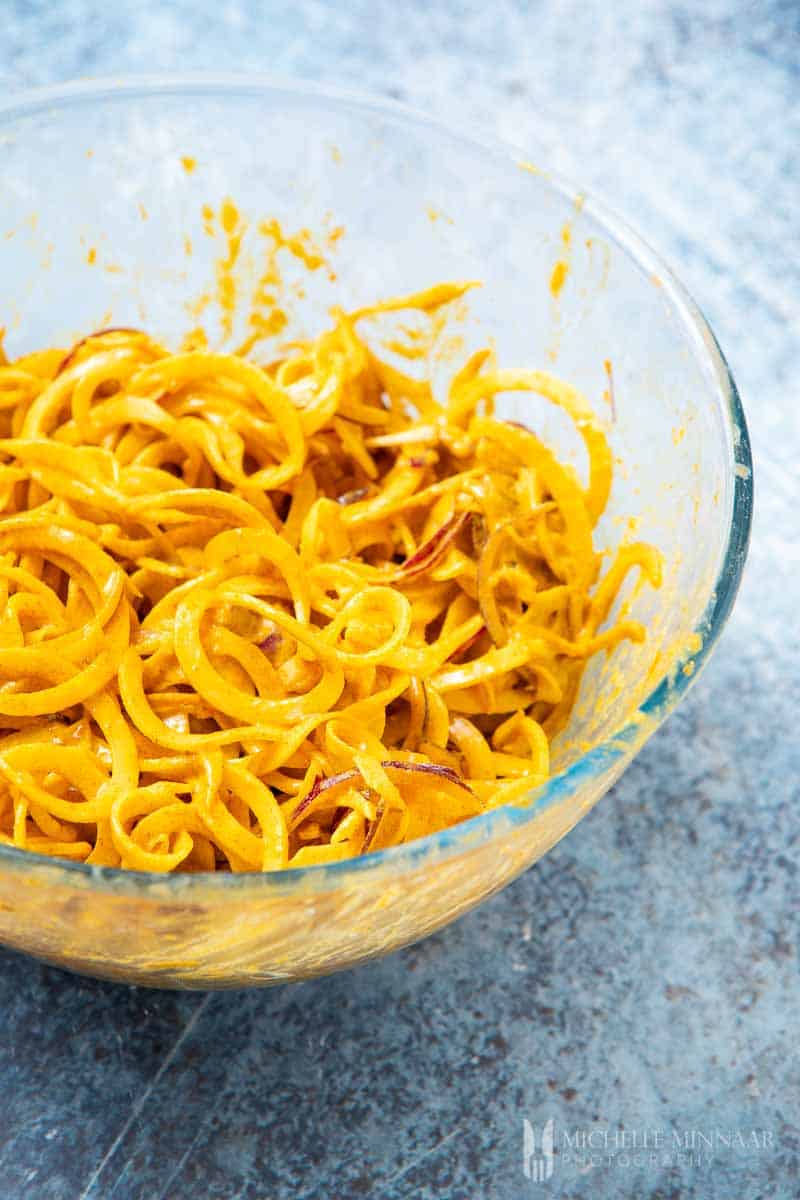 Potato strips covered in orange sauce
