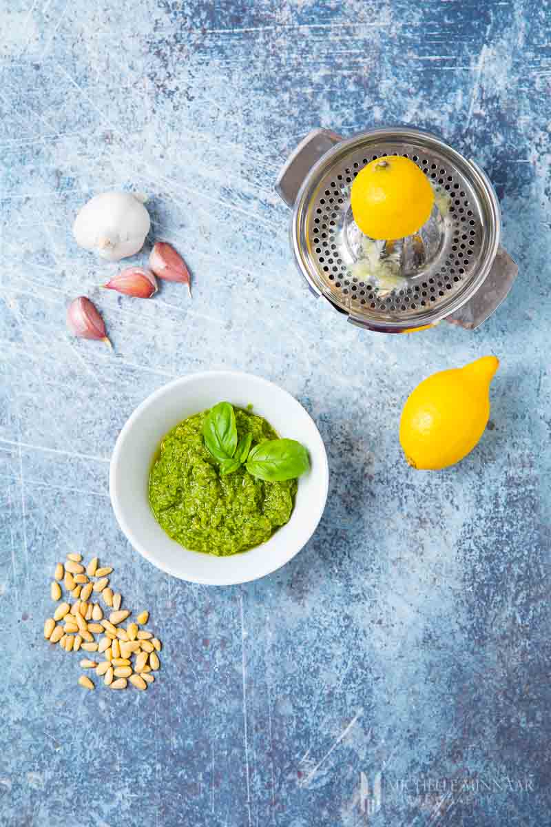 a bowl of green dairy free pesto, lemons and garlic
