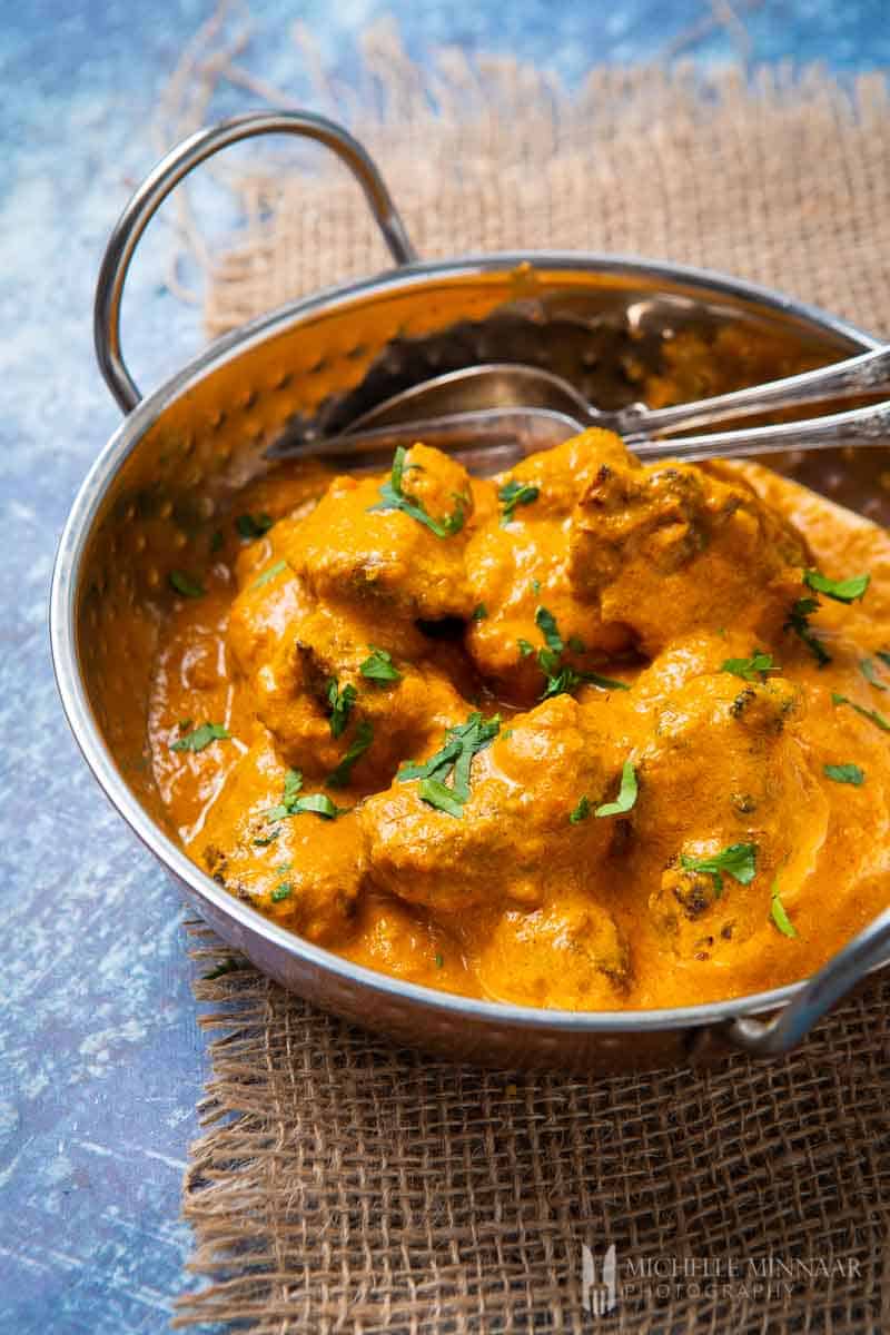 Close up or lamb tikka masala in an orange sauce 