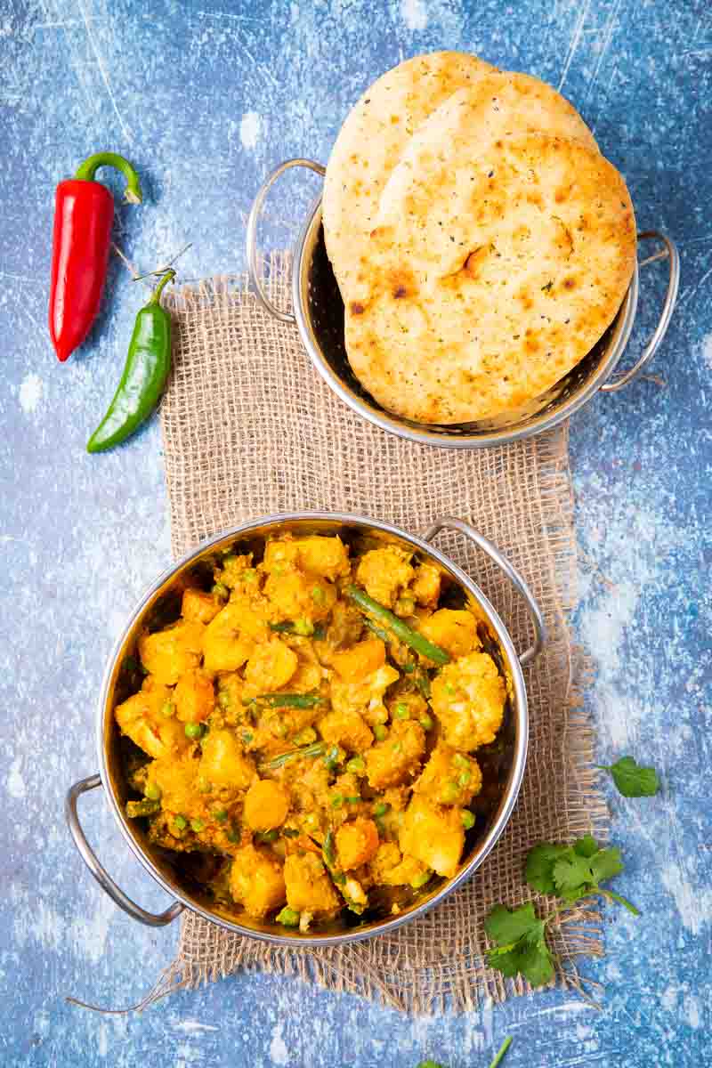 Bowl of mixed vegetable curry and naan