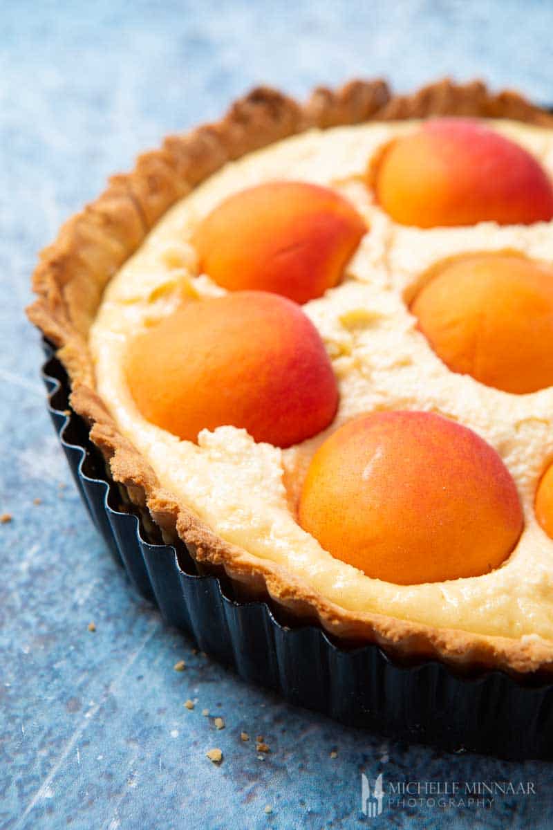 A close up of an apricot tart about to be baked