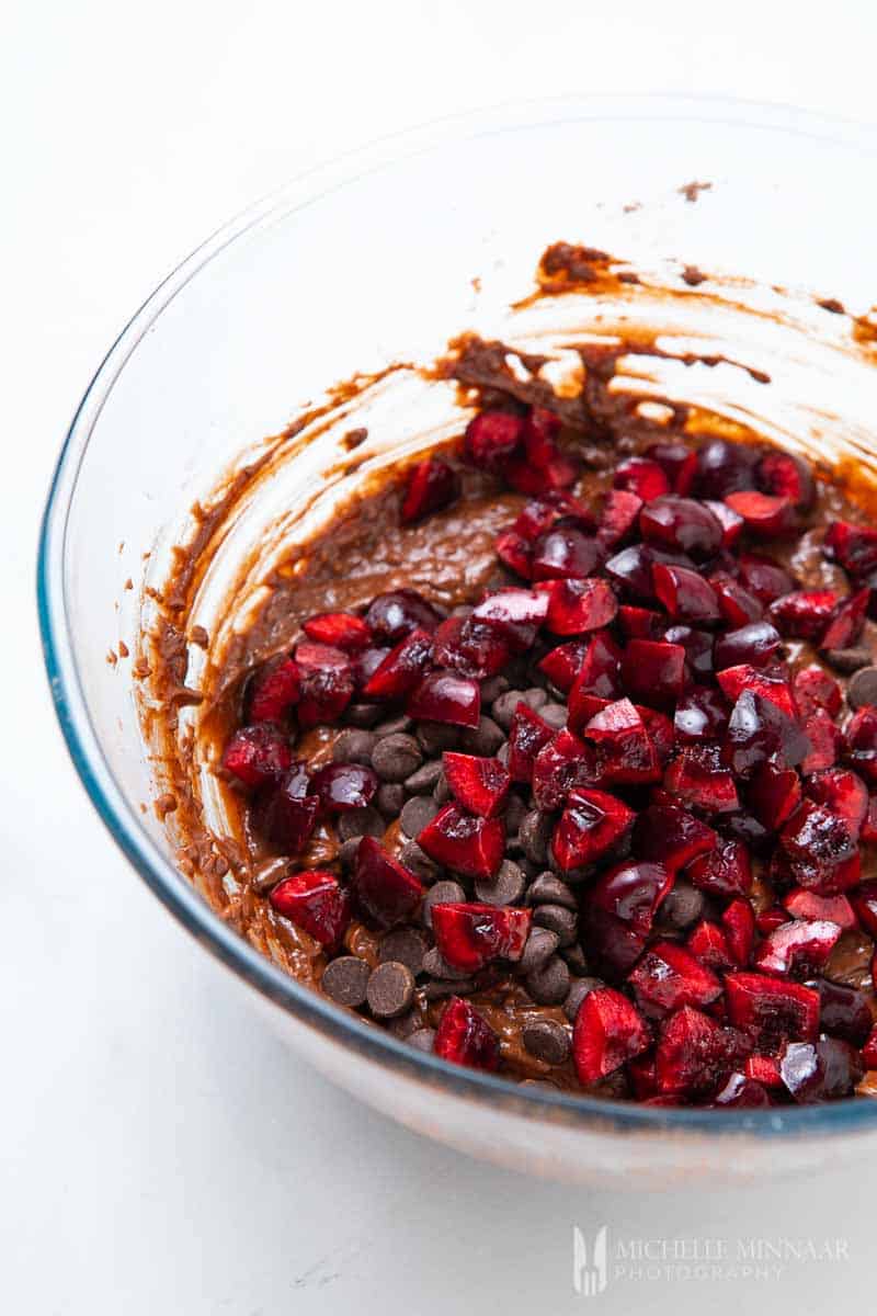a bowl of red chopped cherries and chocolate mixed