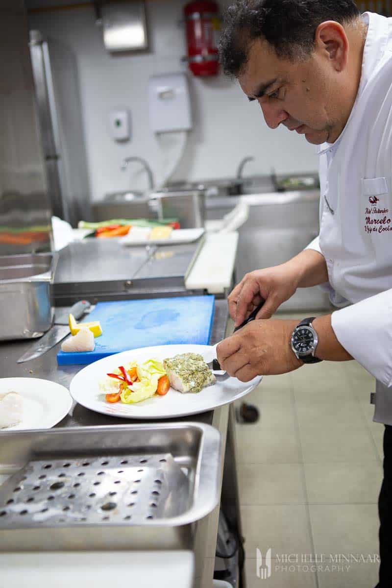 A chef plating steamed cod