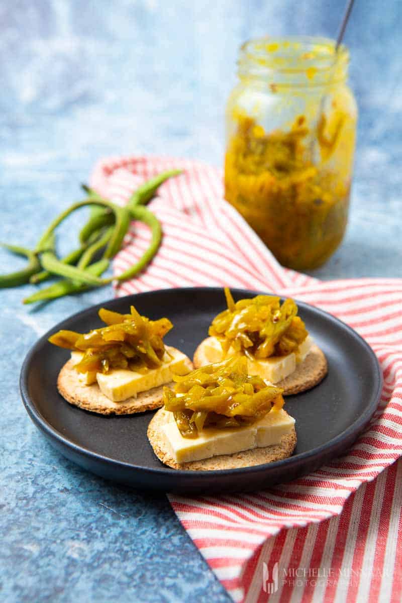 Three crostinis on a plate with runner bean chutney on top 
