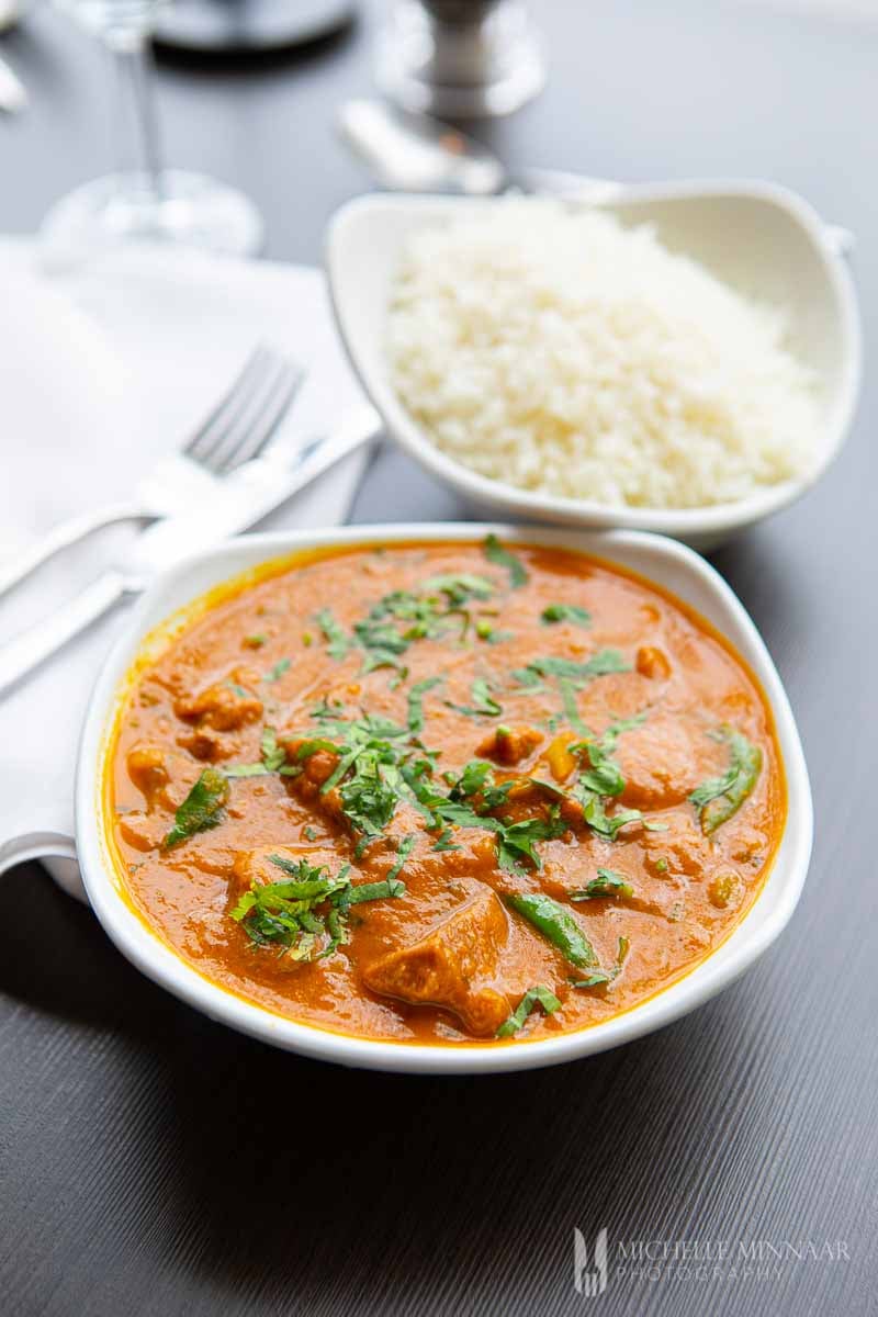 Close up of Indian lamb karahi with green leaves on top 