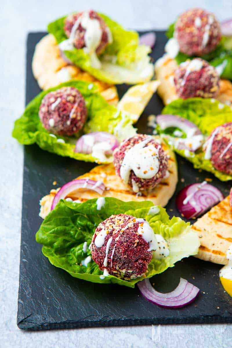 Balls of purple beetroot in beds of lettuce 