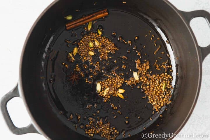 Frying spices in a pan.