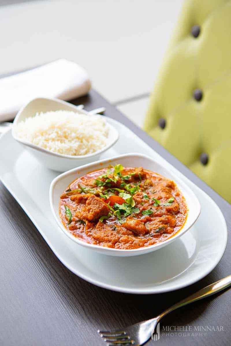 Bowl of lamb karahi and bowl of white rice