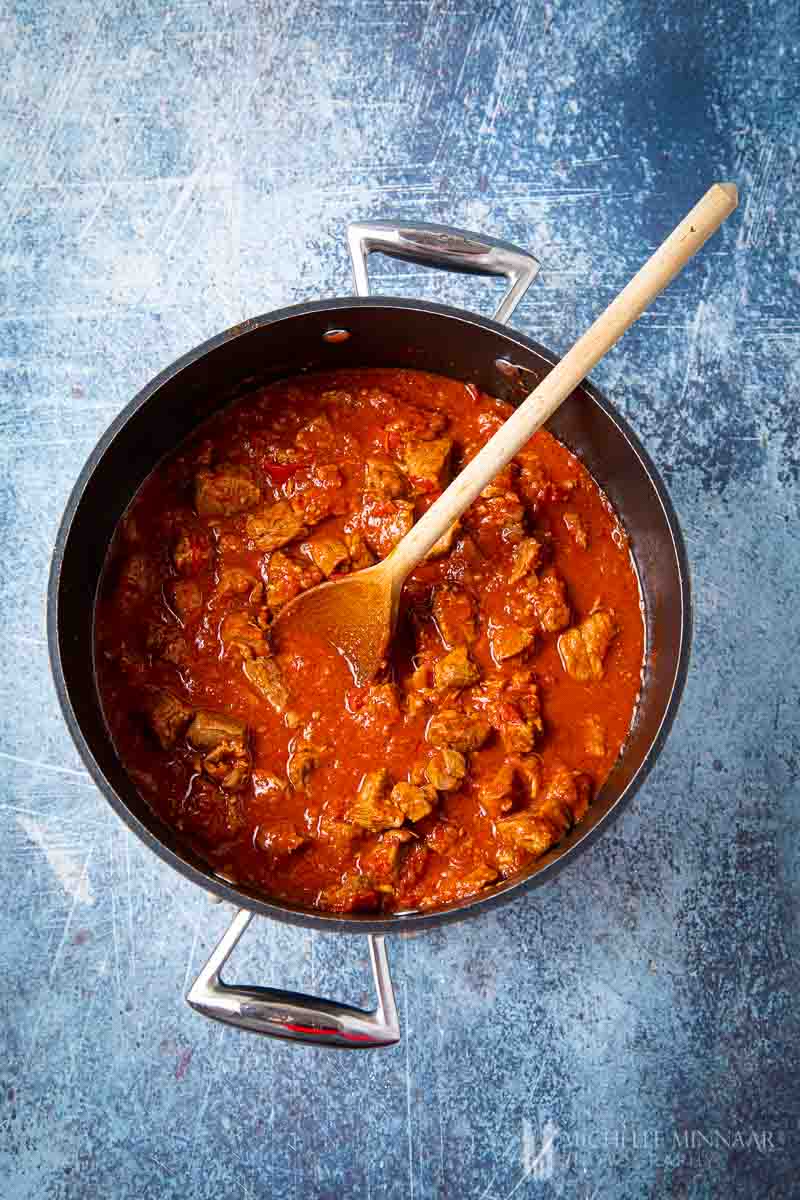 Lamb stewing in a red sauce 