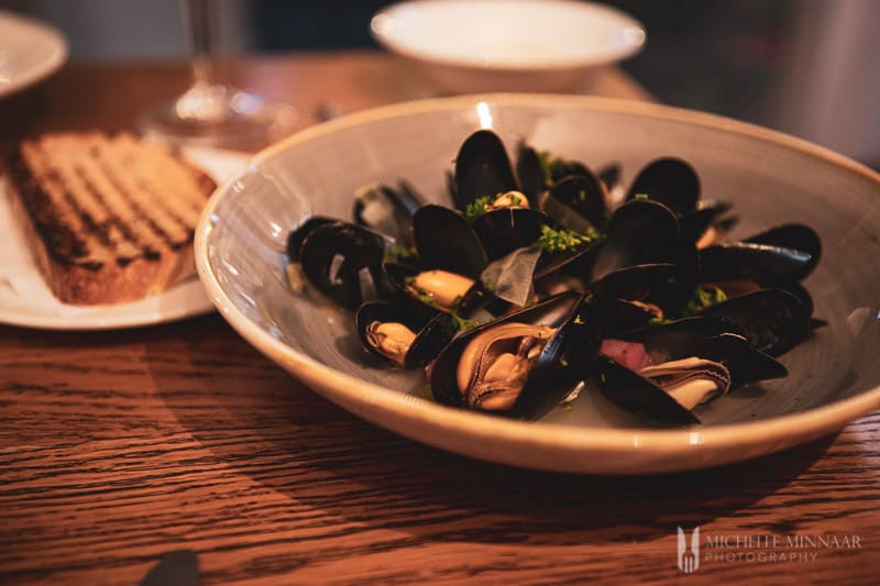 Steamed mussels in a grey bowl.