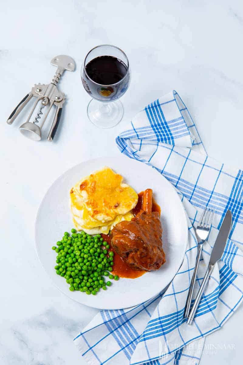 A plate of slow cooker lamb shanks, peas and potatoes 