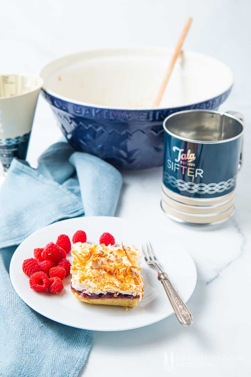 Square slice of Louise cake and a sifter