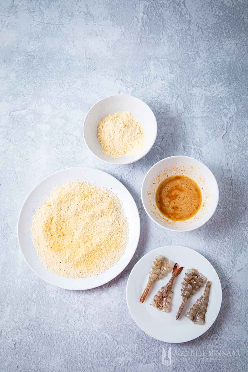 Bowls of crumbs and raw shrimp
