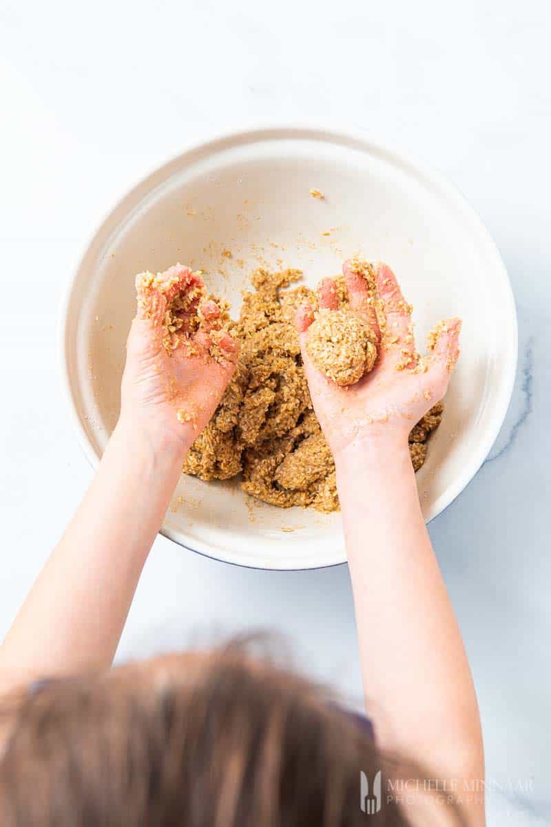 Kids hands forming cookie balls 