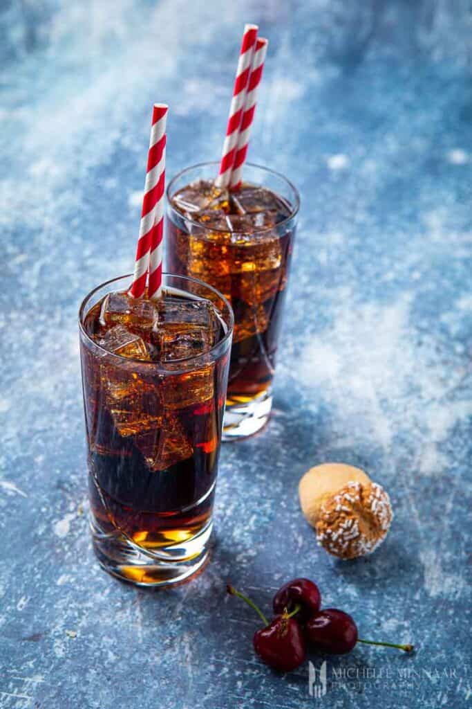 Two clear glasses of amaretto and coke